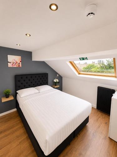 a bedroom with a large white bed and a window at Hotel Albergo in Brussels