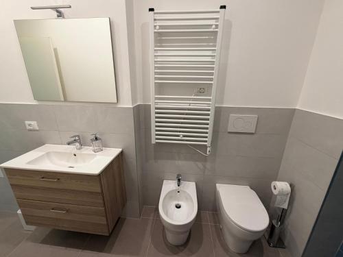 a bathroom with a toilet and a sink and a mirror at Casa Pallacorda in Prato