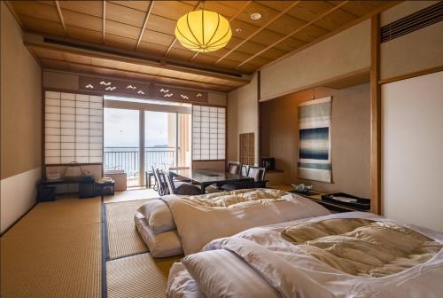 ein Schlafzimmer mit zwei Betten und einem Tisch darin in der Unterkunft Awashima Hotel in Numazu