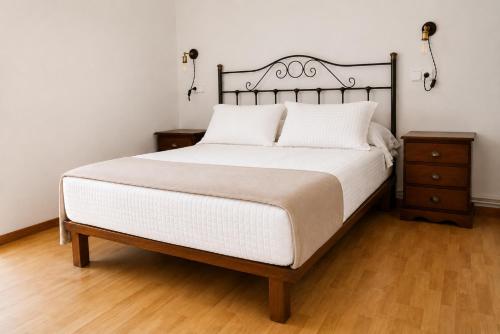 a bedroom with a large bed and a night stand at Casa Cal da Rosins in Muxia