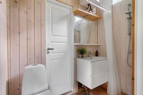 a bathroom with a toilet and a sink and a door at 1605-Dronningmolle-Tarnfalkevej-1 in Dronningmølle