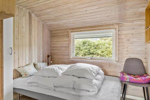 a bedroom with a bed with a window and a chair at LF212-Vestervig-Ingersvej-12 in Vestervig