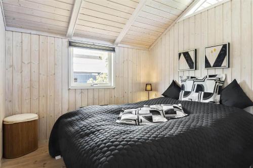 a bedroom with a large black bed with pillows at 30510-Odder-Elmegaardsvej-8 in Odder
