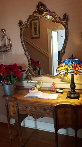 a dressing table with a mirror and a lamp on it at Historic Wilson-Guy House in Niagara on the Lake