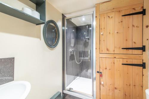 a shower with a glass door in a bathroom at The Forge, Snitterton near Matlock in Moffat