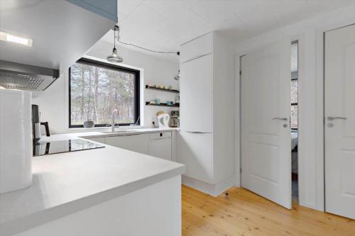 a white kitchen with white cabinets and a window at 84100-Ebeltoft-Magevej-4 in Ebeltoft