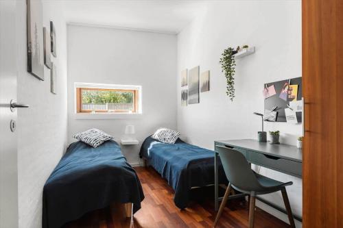 two beds in a room with a desk and a desk at 8250-Ega-Strandvangsvej-52 in Egå