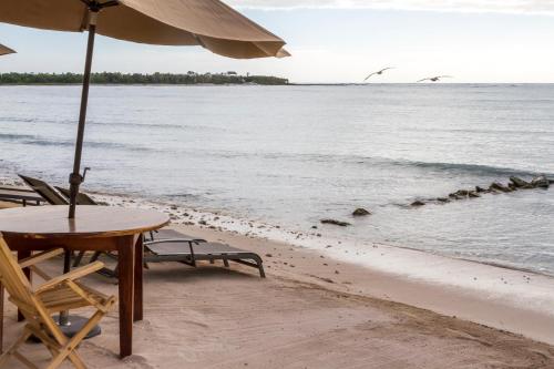a table and chairs on the beach with an umbrella at Cielo Maya Beach Tulum in Tulum