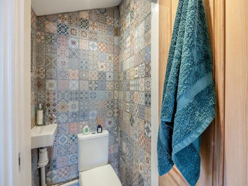 a bathroom with a toilet and a blue towel at 4 Smiddy Hill in Pickering