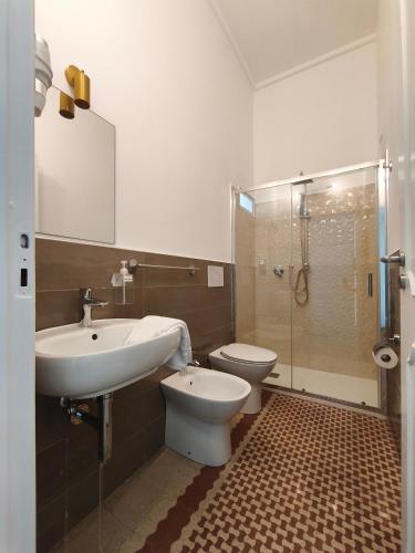 a bathroom with a sink and a toilet and a shower at Palazzo San Giorgio 1924 in Scilla