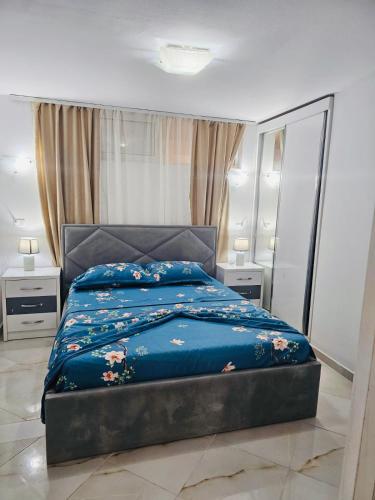 a bedroom with a bed with a blue comforter at Mimoza Appartament in Golem