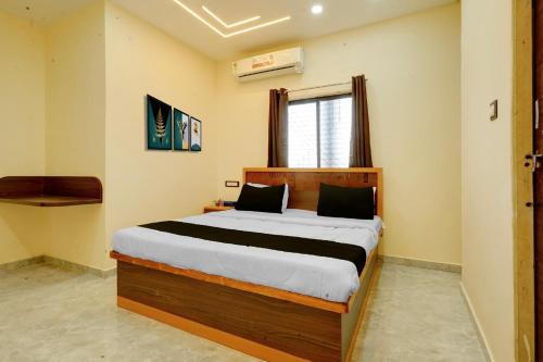 a bedroom with a large bed in a room at HOTEL O VILLAGE in Rāipur