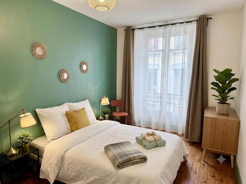 a bedroom with a white bed with a green wall at Cosy Magnolia Quartz - T3 - Hyper centre avec Parking in Pau