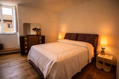 a bedroom with a bed and a dresser and a mirror at Casa Elisabetta in Tuscania