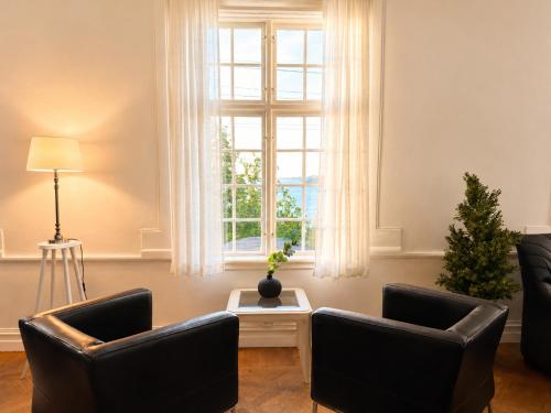 a living room with two chairs and a window at Hotel Carl XII in Ed