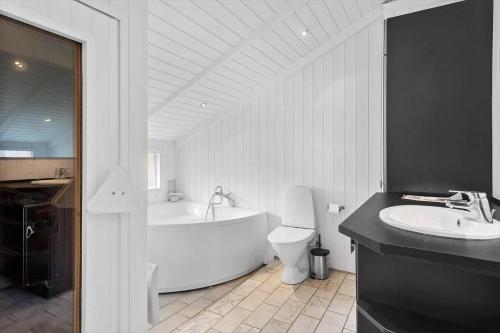 a bathroom with a tub and a toilet and a sink at M300-Vaeggerlose-Stolt-Henriksvej-53 in Bøtø By