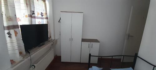 a living room with a television and a white door at Ela Gar 3 WG Zimmer in Garsten