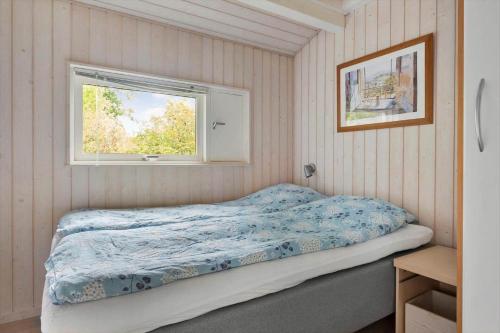 a bed in a room with a window at 1627-Dronningmolle-Svalevej-3 in Dronningmølle