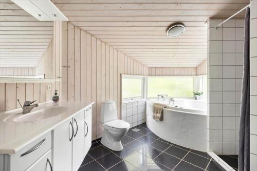 a bathroom with a tub and a toilet and a sink at 1627-Dronningmolle-Svalevej-3 in Dronningmølle