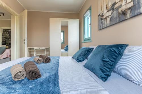 a bed with blue pillows and towels on it at Gina Gedici Resort in Gedići