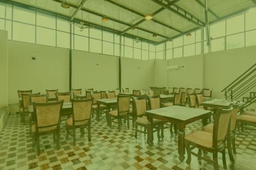 a dining room with tables and chairs and stairs at Prabin Ghatiya Homeinn in Patna