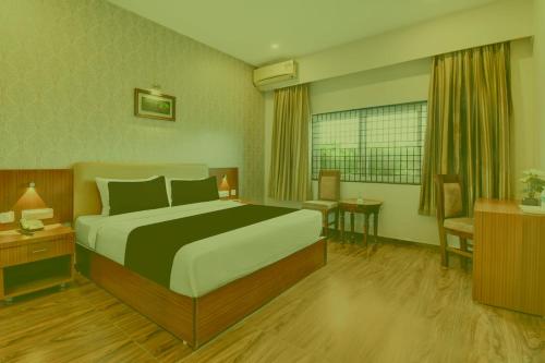 a hotel room with a bed and a table and chairs at Prabin Ghatiya Homeinn in Patna