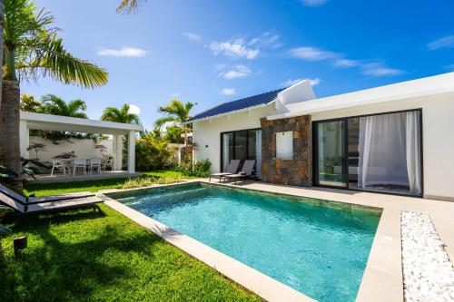 a swimming pool in the backyard of a house at Villa Solis - Elegant & Modern Private Pool Escape in Cap Malheureux