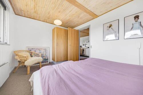 a bedroom with a purple bed and a chair at 30154-Odder-Pouli-Nielsensvej-99 in Odder