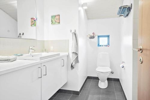 a white bathroom with a sink and a toilet at 30154-Odder-Pouli-Nielsensvej-99 in Odder