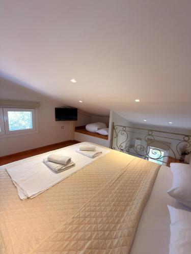 a bedroom with a large bed with white sheets at Thea Suite & Loft in Kavála