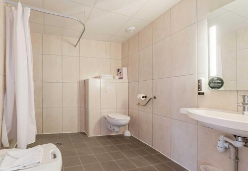 a bathroom with a toilet and a sink at B&B HOTEL Colmar Expo in Colmar