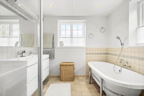 a white bathroom with a tub and a sink at 1523-Vejby-Store-Orebjergvej-53-B in Vejby
