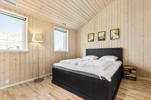 a bedroom with a large bed in a room with wooden walls at 8302-Kolind-Falkevej-34 in Kolind