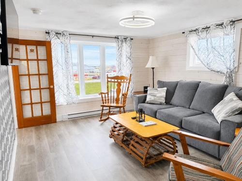 a living room with a couch and a table at Whimsea Cottage in Twillingate