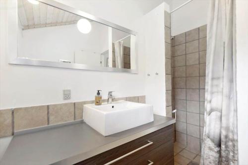 a bathroom with a white sink and a mirror at 84174-Knebel-Fuglsovig-301 in Knebel