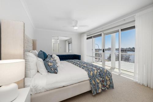 a bedroom with a bed and a large window at Riverfront on The Esplanade 3BDR in Perth