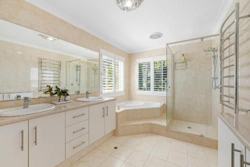 a bathroom with two sinks and a shower at Riverfront on The Esplanade 3BDR in Perth