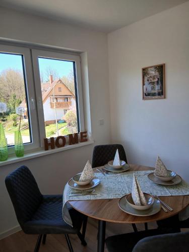 a dining room with a table and chairs and a window at Ferienwohnung Skulpturenweg in Ludwigswinkel