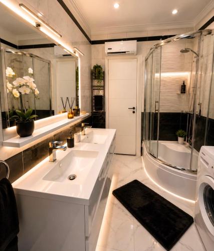 a bathroom with two sinks and a shower and a tub at Apartment "Mimoza 1" self check-in, self check-out in Otočac