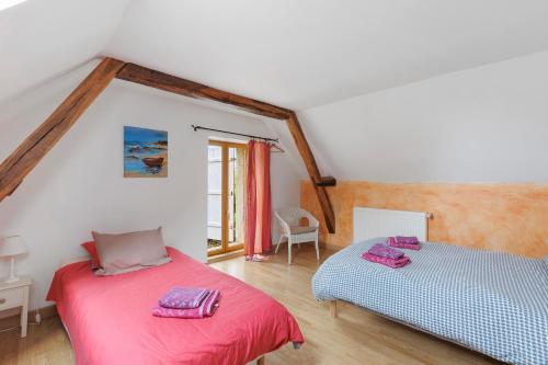 a bedroom with two beds in a attic at Le Café de l'Encloître in Beaumont-la-Ronce