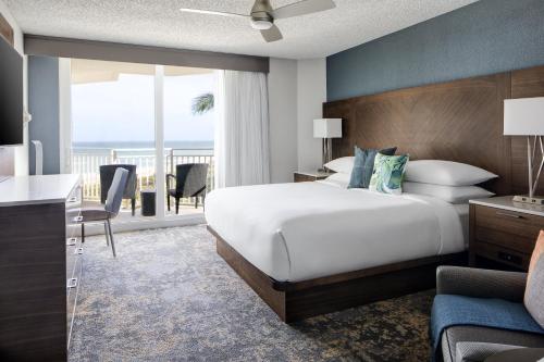 a hotel room with a bed and a balcony at Beach Villas in Stuart