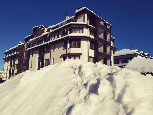a building sitting on top of a pile of snow at Apart Hotel Comfort in Bansko