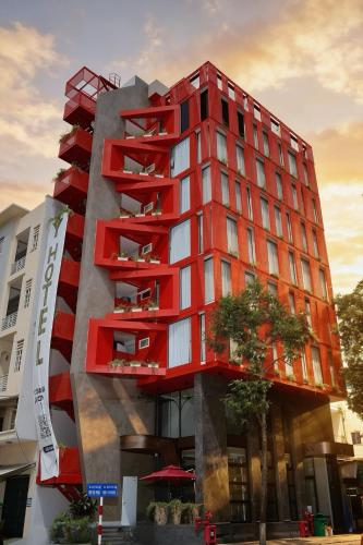a red building with trees in front of it at Y Hotel Phan Đình Phùng in Can Tho