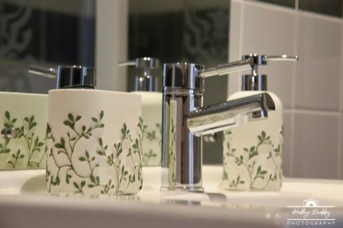a bathroom sink with two paper towels and a faucet at The Kings Arms Hotel, Lostwithiel in Lostwithiel