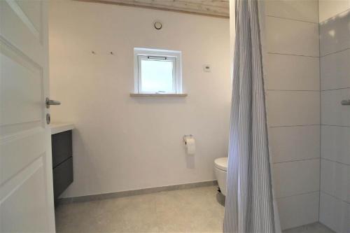 a bathroom with a toilet and a window and a shower at M191-Vaeggerlose-Baeverstien-46 in Bøtø By