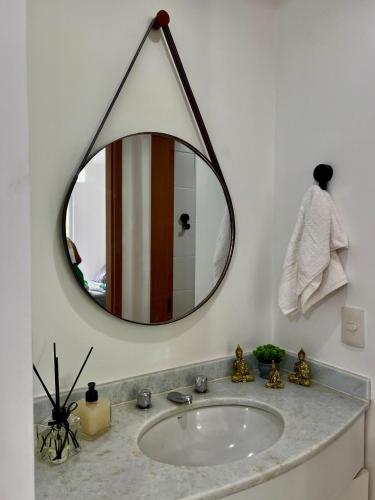 a bathroom sink with a large mirror on the wall at Apartamento Icônico em Petrópolis in Petrópolis