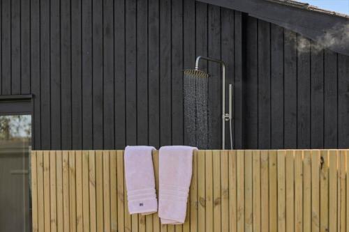 two towels hanging on a fence next to a building at 30111-Odder-Lundgaardsvej-7 in Odder