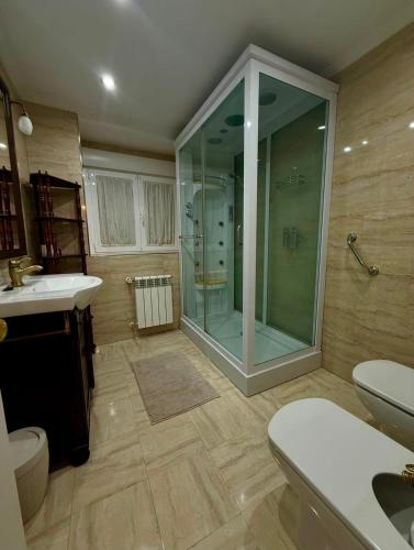 a bathroom with a glass shower and a sink at La casina de isa in Aller