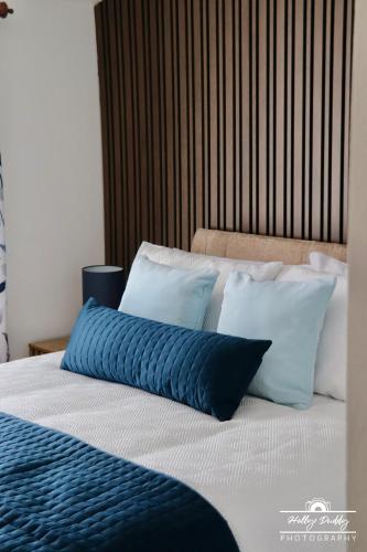 a bed with blue and white pillows on it at The Kings Arms Hotel, Lostwithiel in Lostwithiel