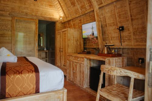 a bedroom with a bed and a tv in a room at Griyani Homestay in Uluwatu